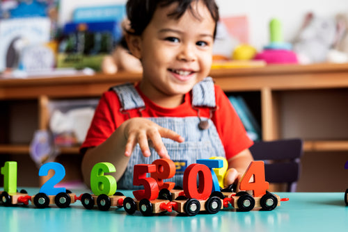 Photo of child playing with a toy train